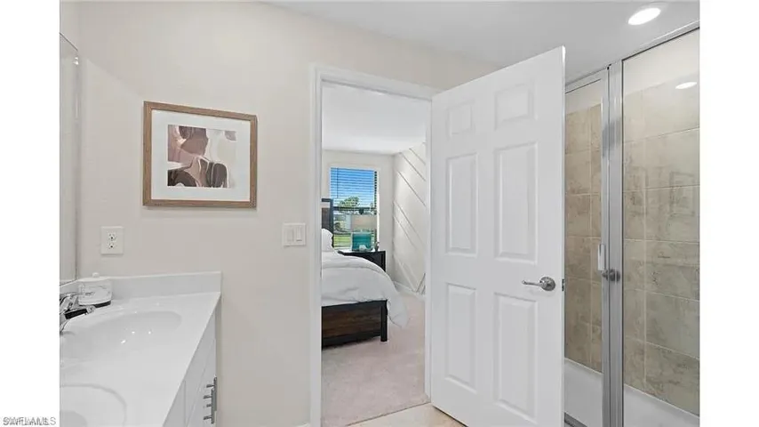 Ensuite bathroom featuring double vanity and a shower stall