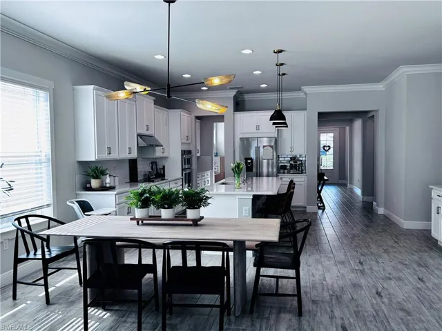 Dining room featuring ornamental molding, recessed lighting, and dark wood finished floors