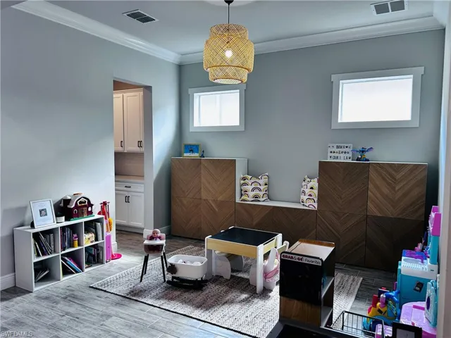 Recreation room featuring crown molding and wood finished floors