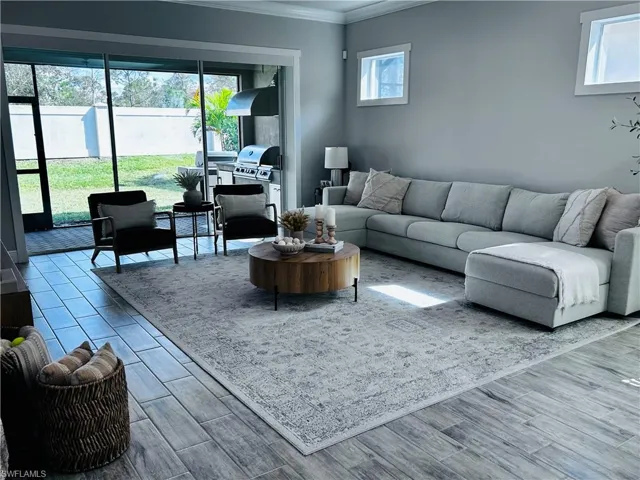 Living room featuring ornamental molding, wood tiled floors, and healthy amount of natural light