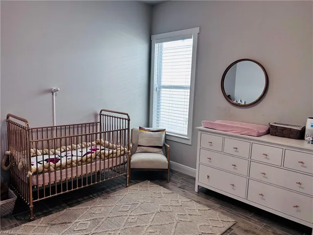 Bedroom with a nursery area and wood tiled floors