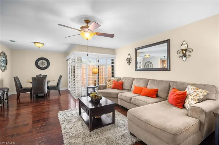 Living area featuring dark wood-style flooring and ceiling fan