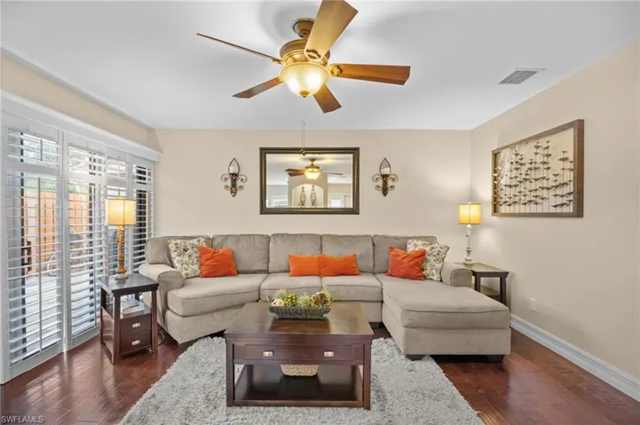 Living room featuring a ceiling fan and dark wood-style flooring