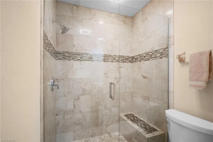 Bathroom with a shower stall and toilet