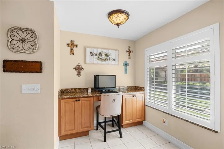 Office featuring light tile patterned flooring and baseboards