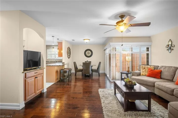 Living area with dark wood-type flooring and ceiling fan