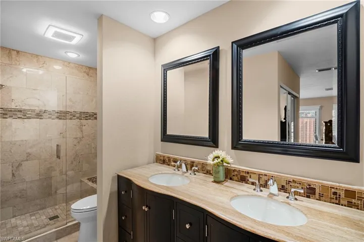 Bathroom featuring a stall shower and double vanity