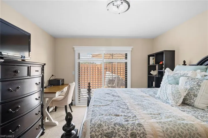 Bedroom featuring a desk and light colored carpet