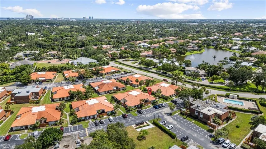 Aerial view of property and surrounding area with a nearby body of water and nearby suburban area