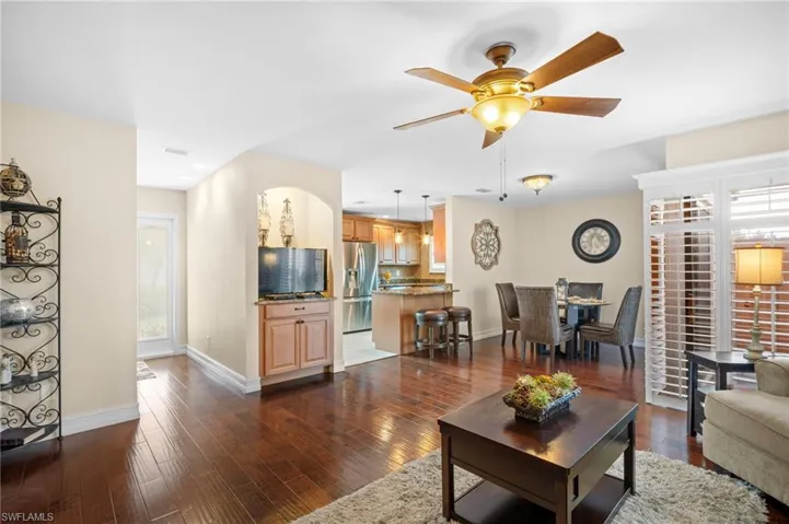 Living room featuring dark wood finished floors, a ceiling fan, and recessed lighting