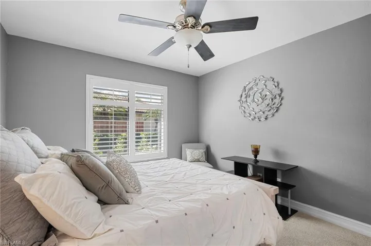 Carpeted bedroom featuring baseboards and ceiling fan