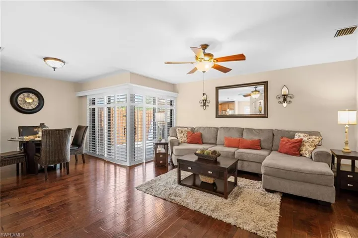 Living room featuring dark wood-type flooring and a ceiling fan