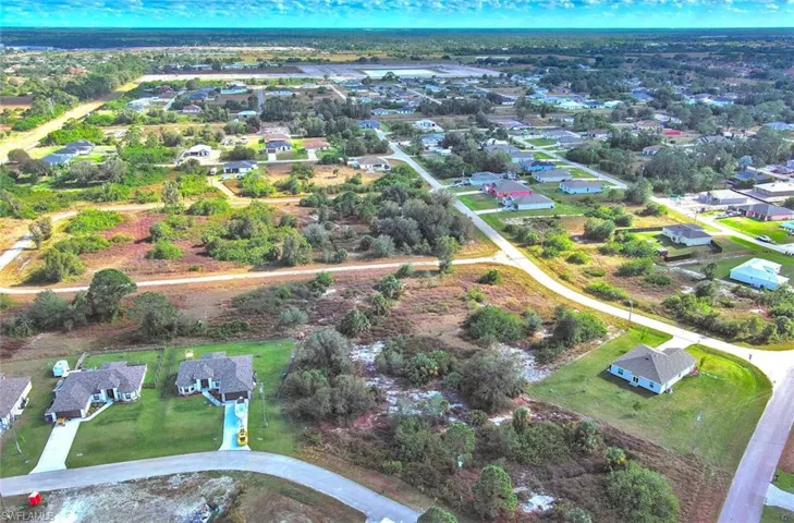 Aerial view of property and surrounding area featuring nearby suburban area