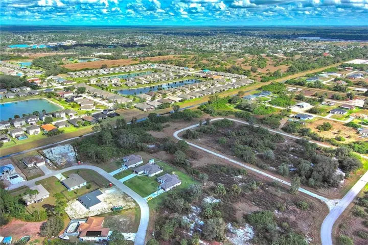 Aerial view of property and surrounding area with nearby suburban area