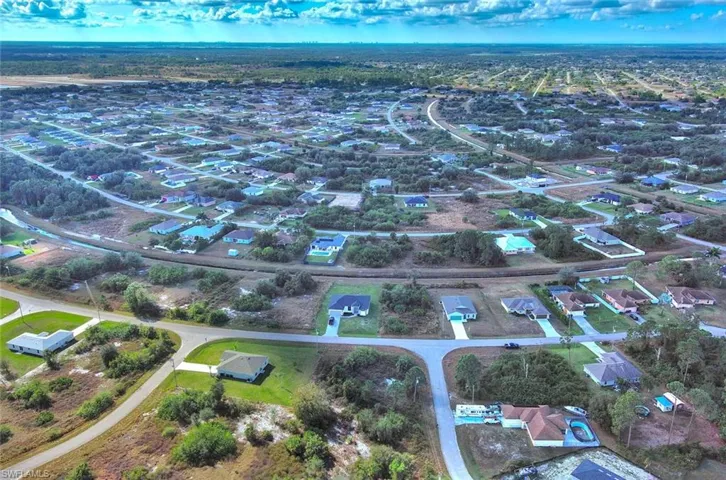 Aerial view of property and surrounding area featuring nearby suburban area