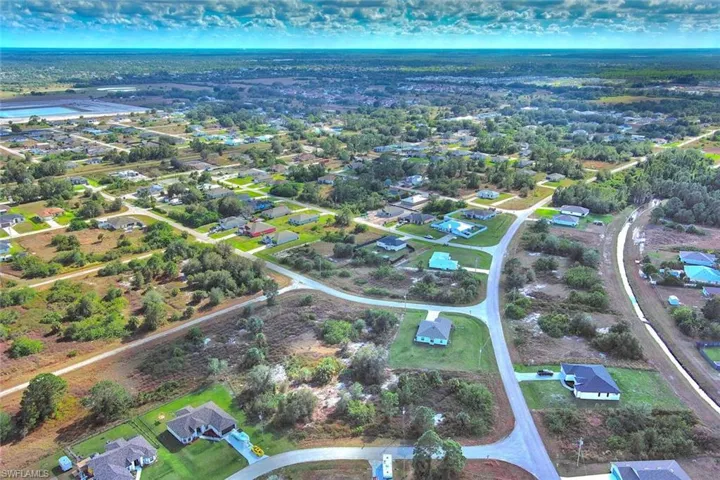 Aerial view of property and surrounding area featuring nearby suburban area