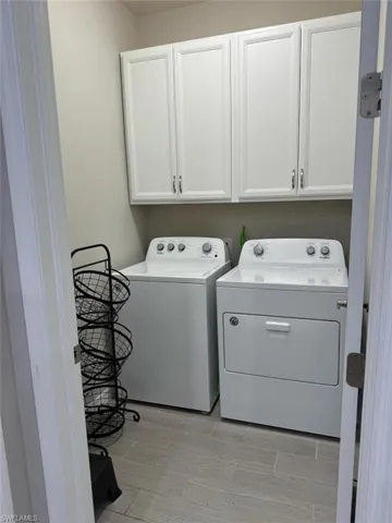 Washroom featuring washer and dryer and cabinets
