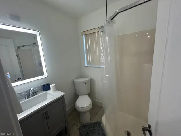 Bathroom featuring a shower with shower curtain and vanity