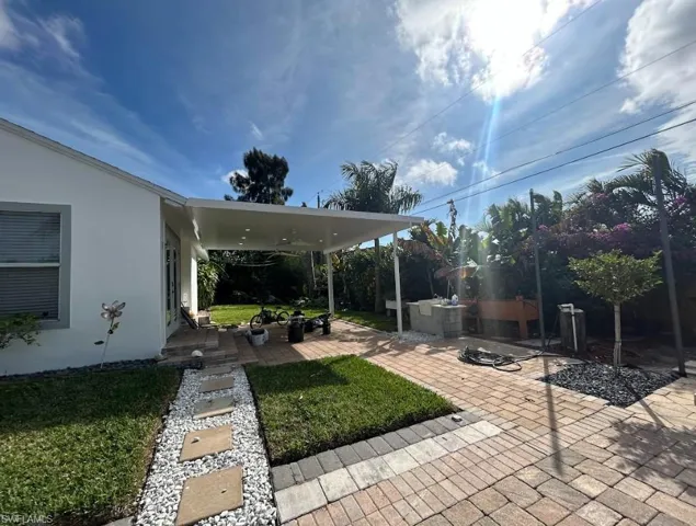 View of grassy yard featuring a patio area and a deck