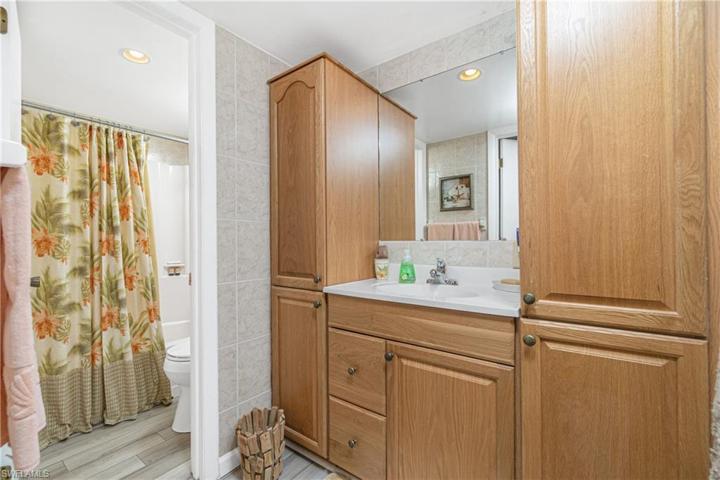 Hall bath has door to tub/ toilet & tall linen storage cabinets.