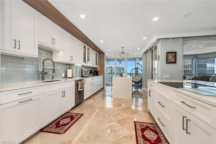 Kitchen featuring white cabinets, backsplash, stainless steel dishwasher, a sink, and glass insert cabinets