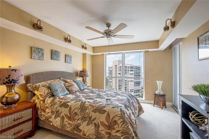 Carpeted bedroom featuring ceiling fan, baseboards, and access to outside
