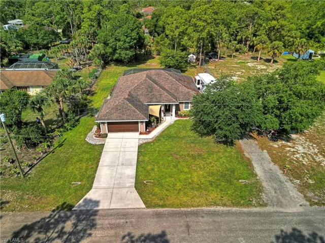 The property features a well-maintained lawn, a spacious driveway, and a two-car garage