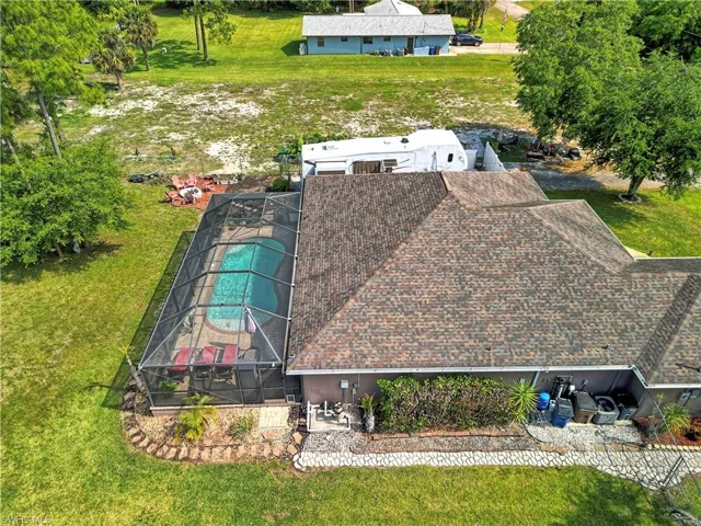 The property features a screened-in swimming pool and a well-maintained lawn