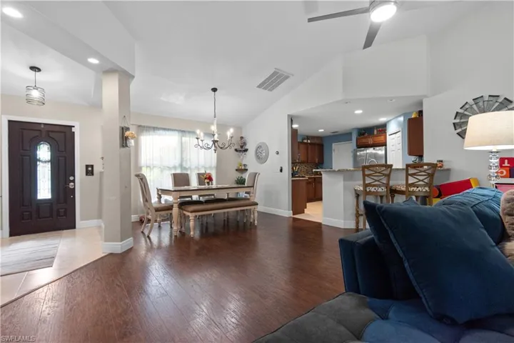 This open-concept living area features rich hardwood flooring and vaulted ceilings