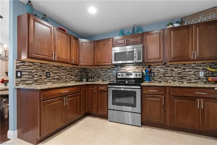 The kitchen feature granite countertops, a tile backsplash, stainless steel appliances and plenty of cabinetry
