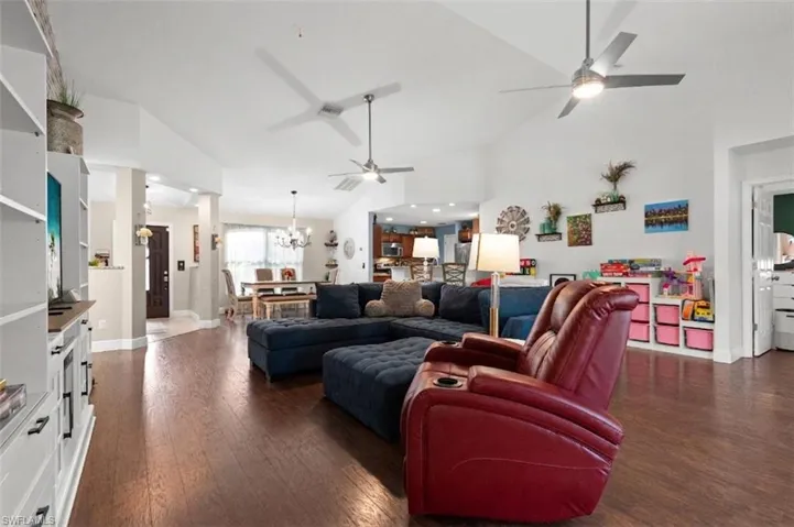 The living area features hardwood floors and a vaulted ceiling with ceiling fans