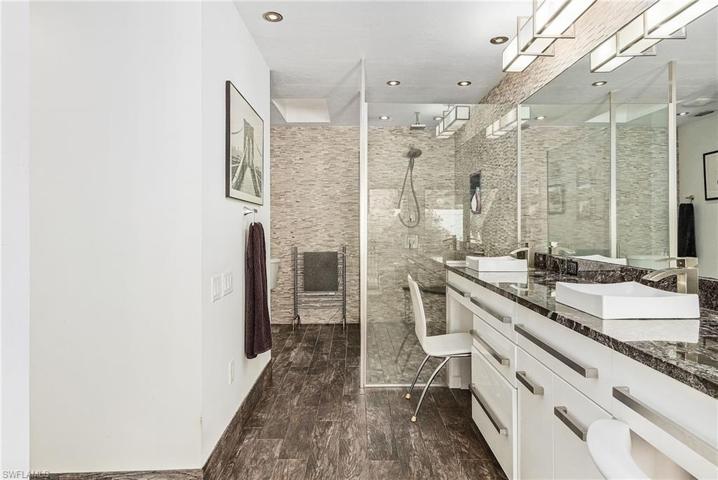 Master bath features large walk-in shower with detailed tile work, shower pan head, halogen lighting.