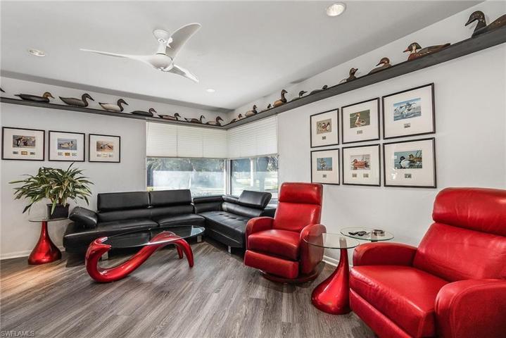 Large den area has tile floors, storage closet, lighted ceiling fan.