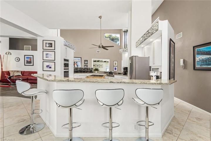 Breakfast bar with plenty of seating, granite tops. tile floors.