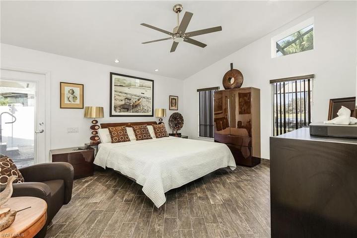 Spacious owners suite has tile floors, 2 walk-in closets, lighted ceiling fan, access out to open patio.
