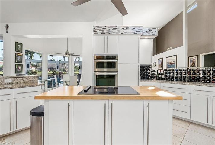 Sleek, open kitchen with SS appliances, granite tops, butcher block island.
