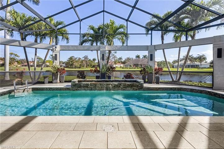 Stunning pool area with water feature and expansive lake to golf course views.