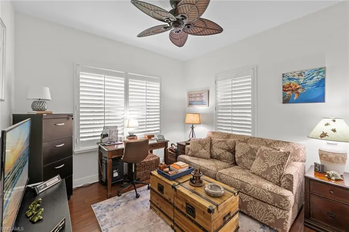 This room features hardwood floors, white walls, and a ceiling fan