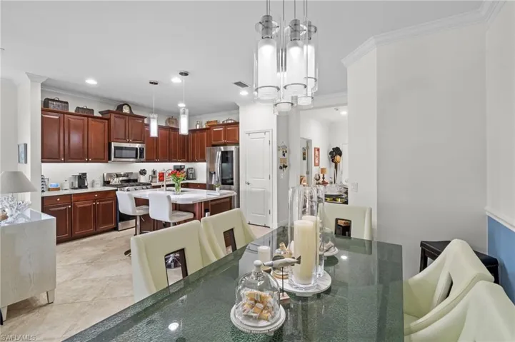 The kitchen features dark wood cabinetry, stainless steel appliances, and an island with seating