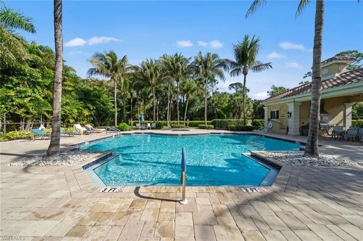 The property features a large outdoor swimming pool with an integrated spa, surrounded by a paved deck