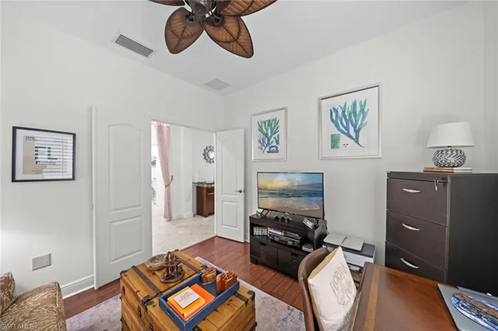 This versatile room features hardwood floors and a ceiling fan, offering a bright and functional space