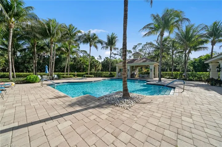 The property features a swimming pool with a paved patio surround, a gazebo, and numerous palm trees