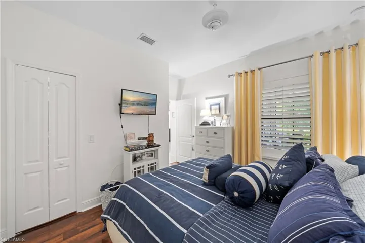 This room features hardwood floors, white walls, and a ceiling fan