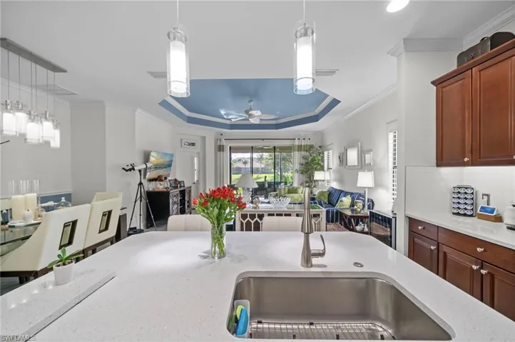 The kitchen features a spacious island with a stainless steel sink and a light-colored countertop