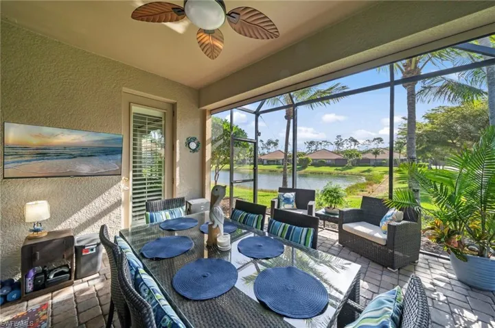 The screened patio features a ceiling fan, tiled flooring, and a dining area with a glass-top table