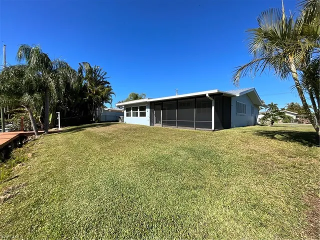 View of yard with a sunroom and screen room.  Walk out to your own dock and rip rap for a natural bank.