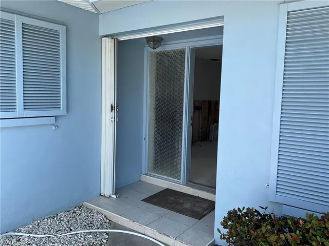 Front Doorway to property featuring according storm protection.