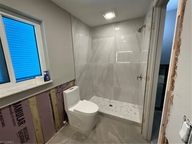 Bathroom featuring a shower w/tile and a great window for light and storm protection.