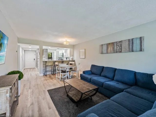 Living room with light wood-type flooring and a textured ceiling