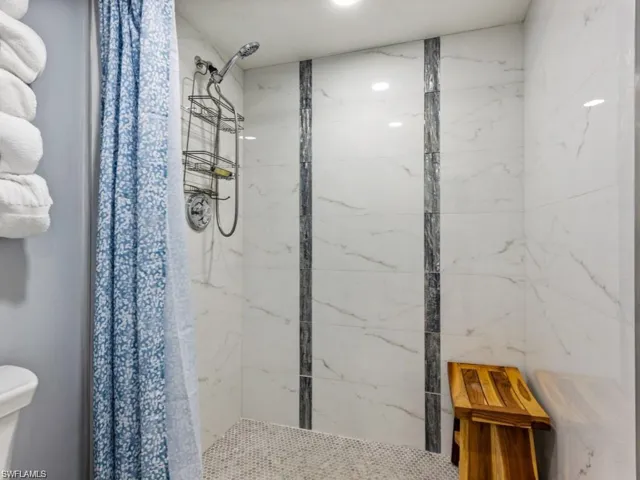 Bathroom with a marble finish shower
